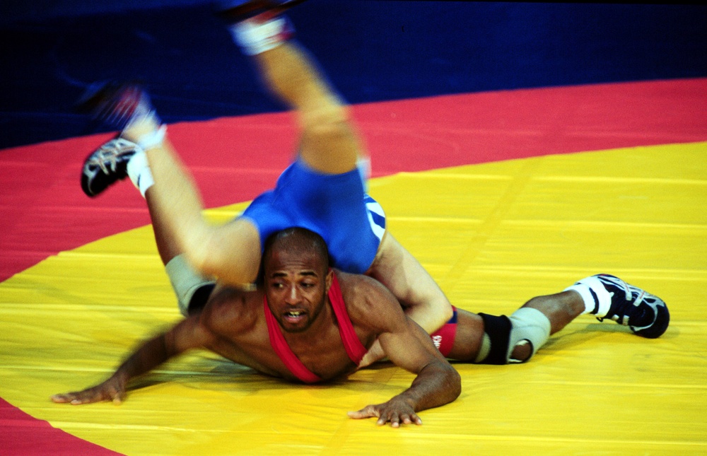 Petty Officer Steven Mays tries to fight off being pinned by Uran Kalilov during their Greco-Roman wrestling match.