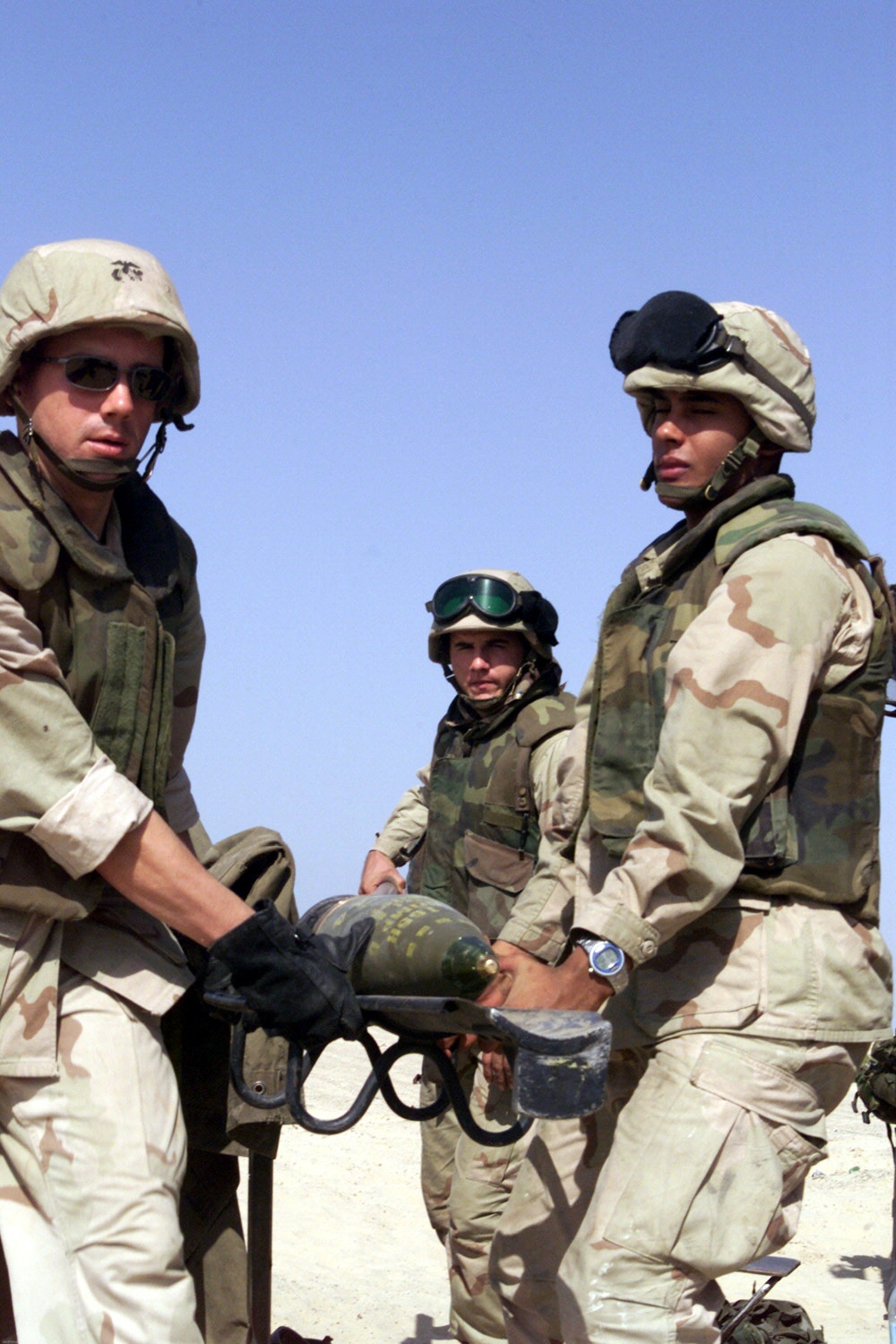 Cpl. Dewayne Coleman, Lance Cpls. T.J. Hart and Arlie Jordan prepare to load a 155 mm artillery shell into an M-198 howitzer.