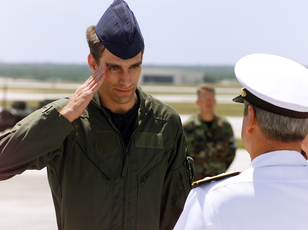 Air Force Senior Airman Curtis Towne salutes as he goes through a receiving line after arriving at Andersen Air Force Base, Guam.