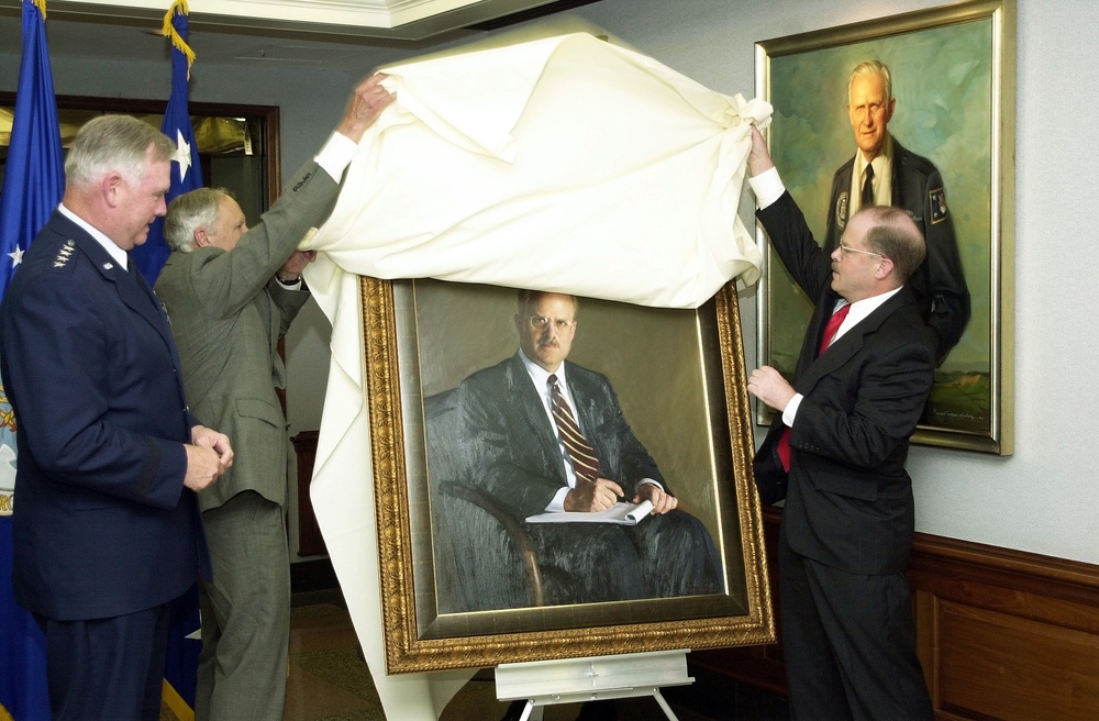 Former Secretary of the Air Force F. Whitten Peters and portrait artist Peter Egeli unveil Peters' official portrait at the Pentagon.