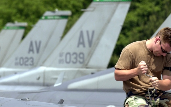 Airman 1st Class John McKivitz performs an operational check on the air refueling door of an F-16 Fighting Falcon.