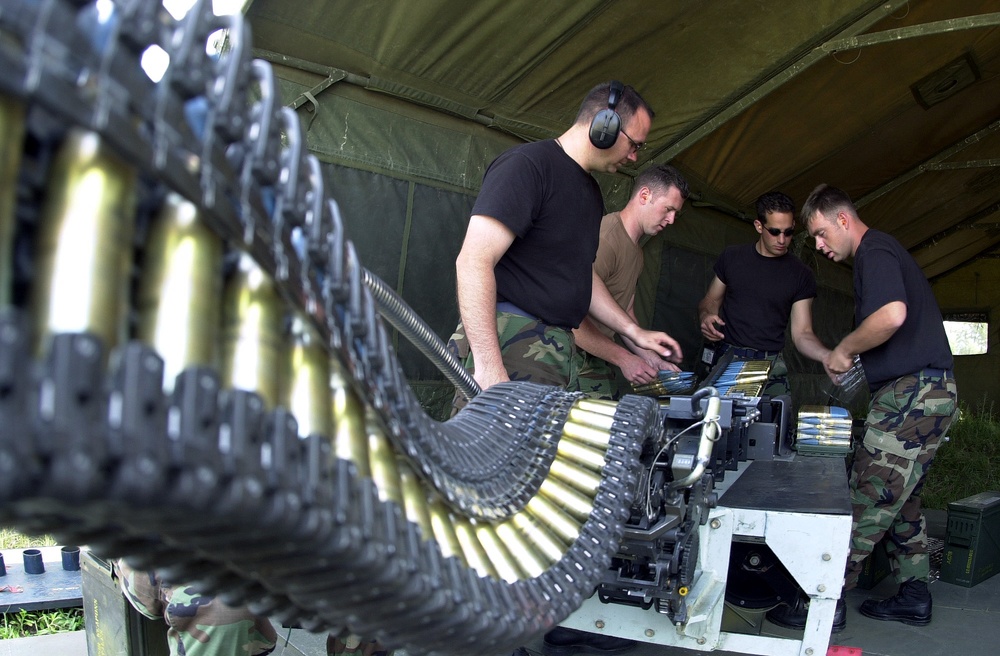 Staff Sgts. Straley, Hurley, Schoenly and Senior Airman Tremblay upload 20 mm ammunition into an F-16 Fighting Falcon.