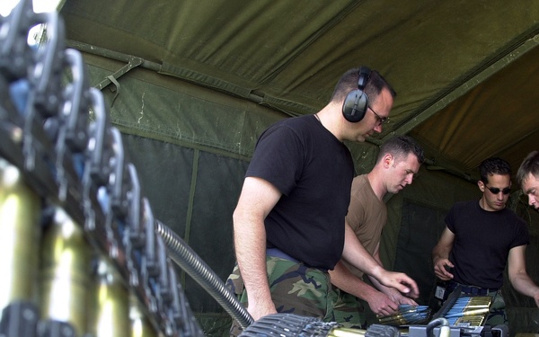 Staff Sgts. Straley, Hurley, Schoenly and Senior Airman Tremblay upload 20 mm ammunition into an F-16 Fighting Falcon.