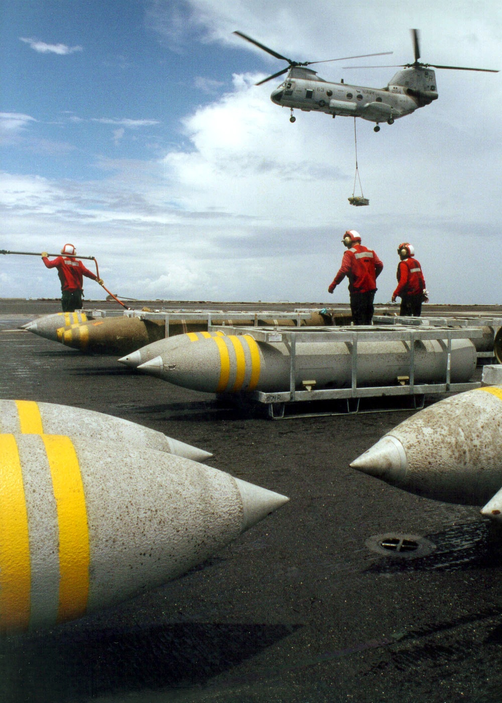 A Sea Knight helicopter delivers another pallet of bombs to the flight deck of the USS John F. Kennedy.