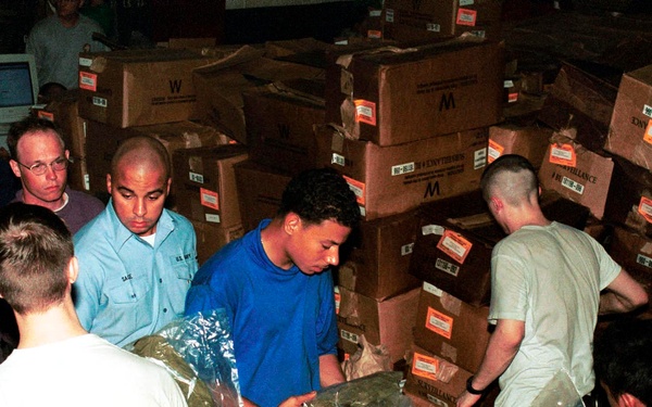 Crew men of the USS Enterprise line up to receive an Advanced Chemical Protective Garments.