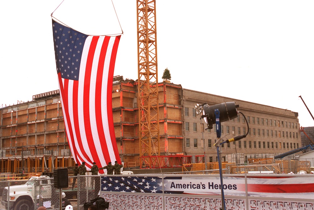 U.S. Army soldiers help unfurl a large American Flag in preparation for a Pentagon ceremony.