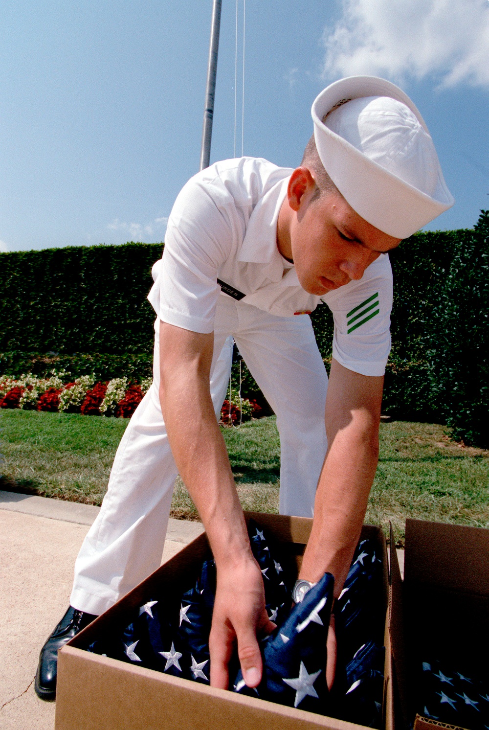 Navy Seaman Apprentice Burden packs a flag after raising it at the Pentagon.