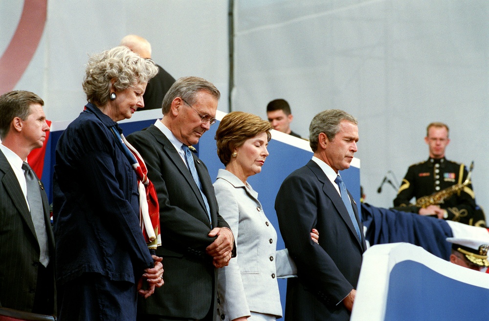 With their heads bowed during the invocation, the Rumsfelds and Bushes take part in the Sept. 11 Observance Ceremony.