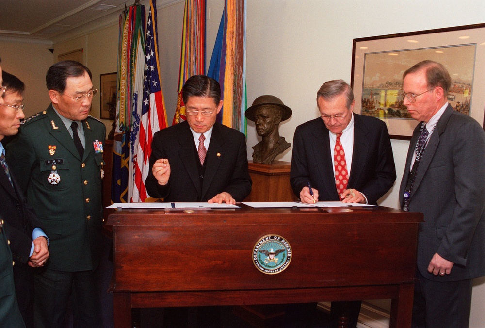 Secretary Rumsfeld and South Korean Minister of National Defense Lee Jun sign documents.