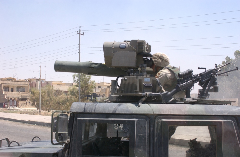 A soldier of the 101st Airborne Division looks through the sights of a TOW missile launcher at a building suspected of harboring Saddam Hussein's sons.