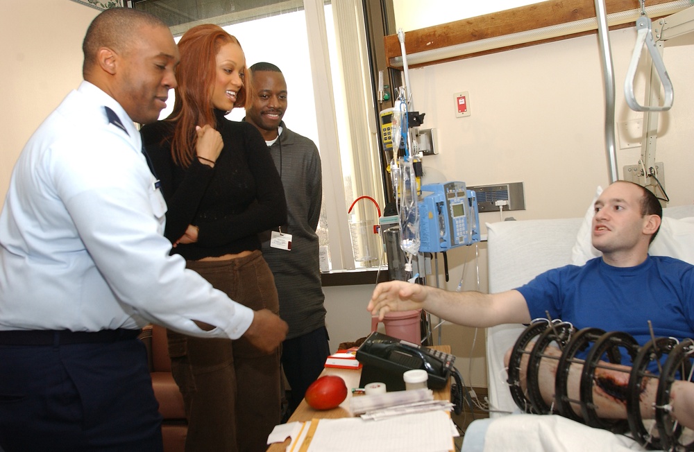 Tyra Banks and her brother, 1st Lt. Devin Banks, visit with Army Pfc. Joseph Kashnow.