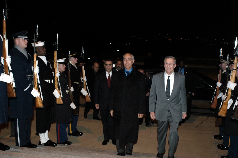 Secretary Rumsfeld escorts Prime Minister Driss Jettou, of Morocco, through a cordon and into the Pentagon.