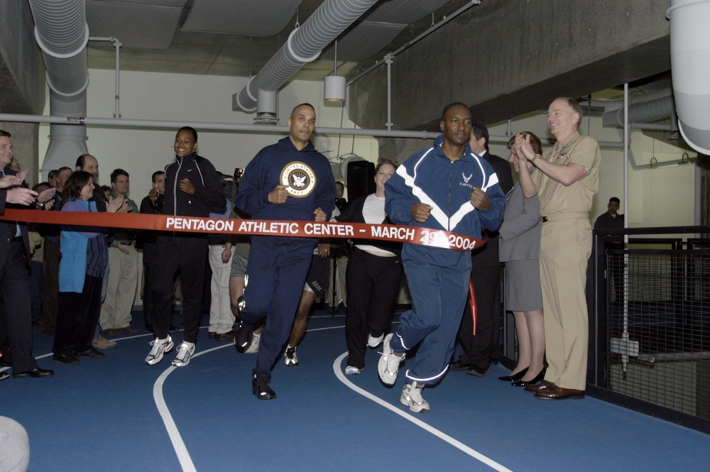 Marion Jones and Department of Defense representatives finish the first ceremonial lap around the new Pentagon Athletic Center track.