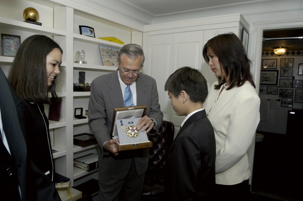 Secretary Rumsfeld shows Kevin Young the Presidential Medal of Freedom with Distinction he received from President Ford.