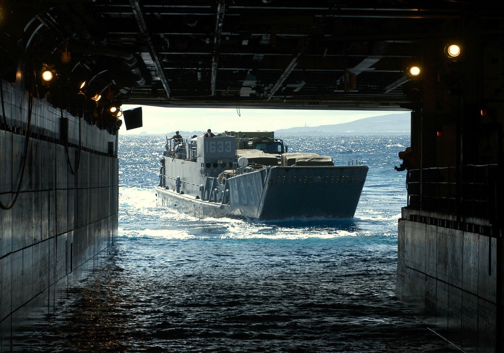 A Landing Craft Utility approaches the well deck of the amphibious assault ship USS Tarawa (LHA 1).