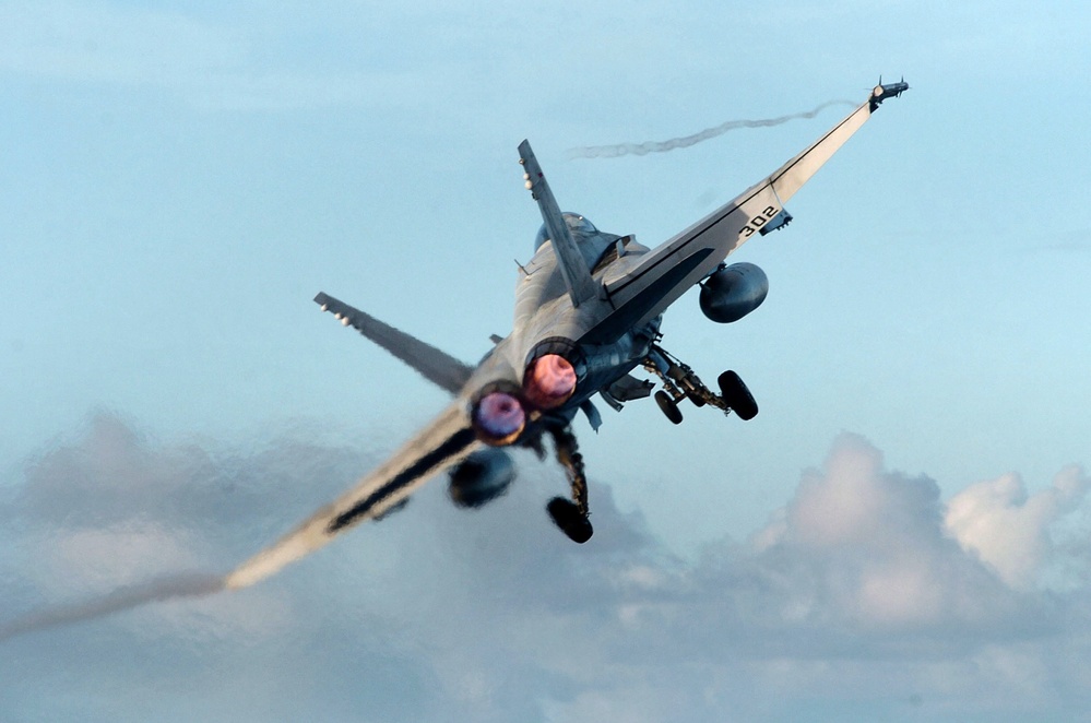 An F/A-18C Hornet launches from the flight deck of the USS John C. Stennis (CVN 74).