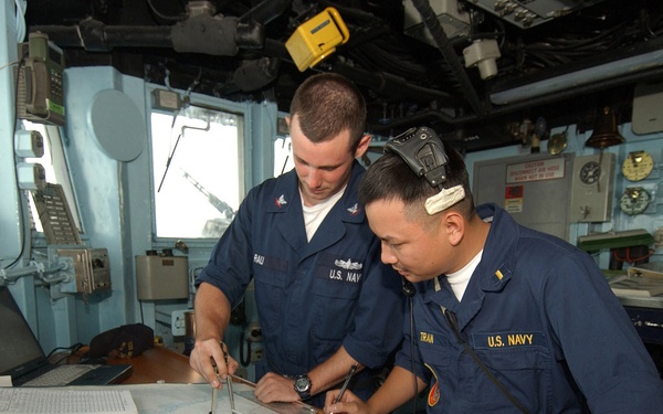 Petty Officer 3rd class Seth Rau and Ensign Tin Tran plot a new course.