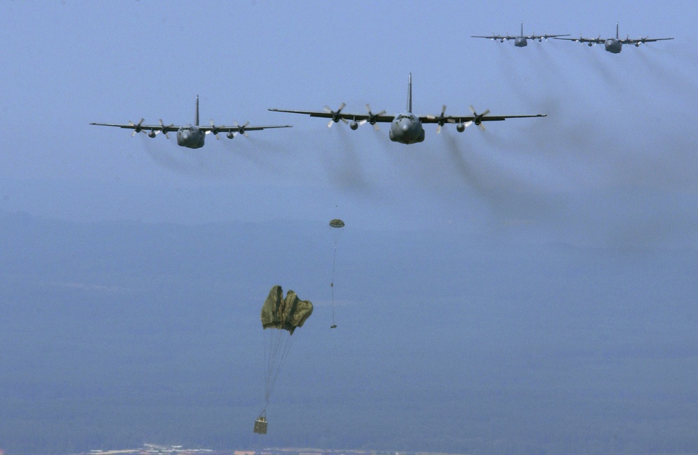 Air Force C-130 Hercules aircraft drop equipment over Grafenwoehr, Germany.