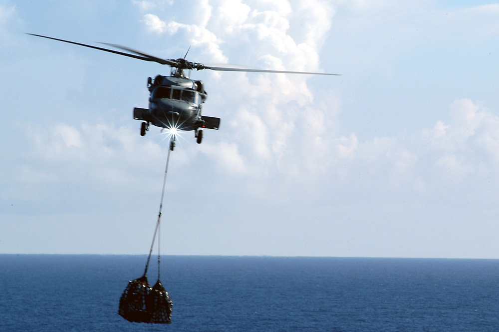 An HH-60H Seahawk transfers supplies to the USS Kitty Hawk (CV 63).