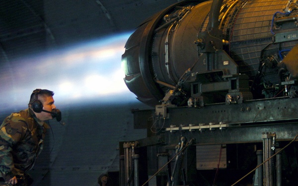 Staff Sgt. Daniel Guerra looks for fuel leaks in an F-16 fighter engine.
