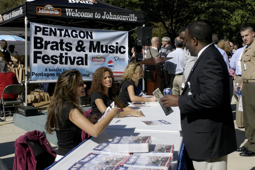 Washington Redskins' Cheerleaders autograph photos during the Pentagon Brats and Music Festival.