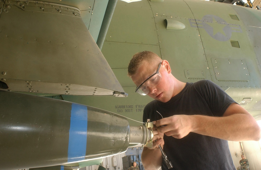 Airman 1st Class Langbehn measures the length of the arming wire to ensure the bomb is flight ready.