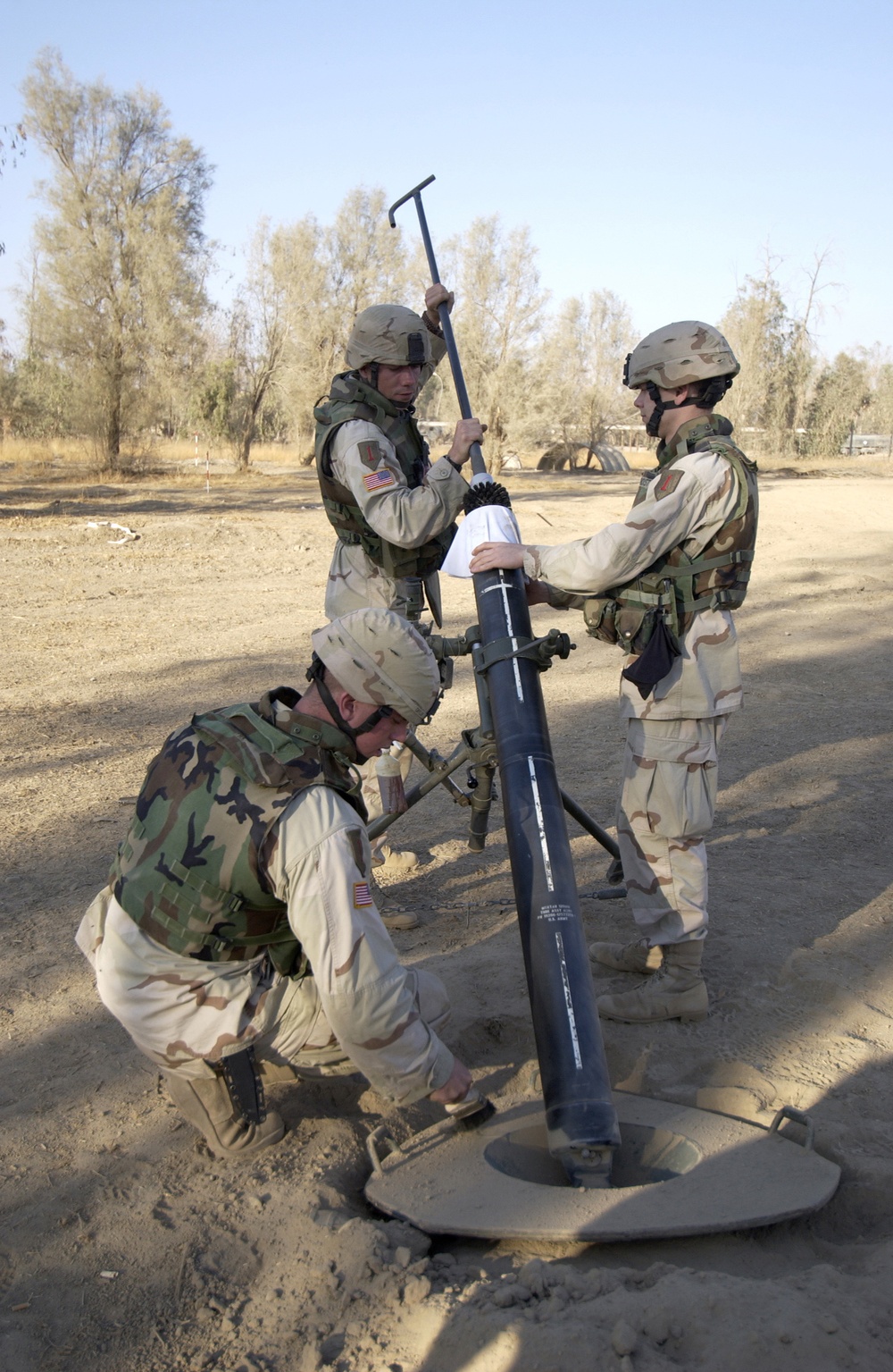 U.S. Army soldiers clean their 120-millimeter mortar tube after firing.