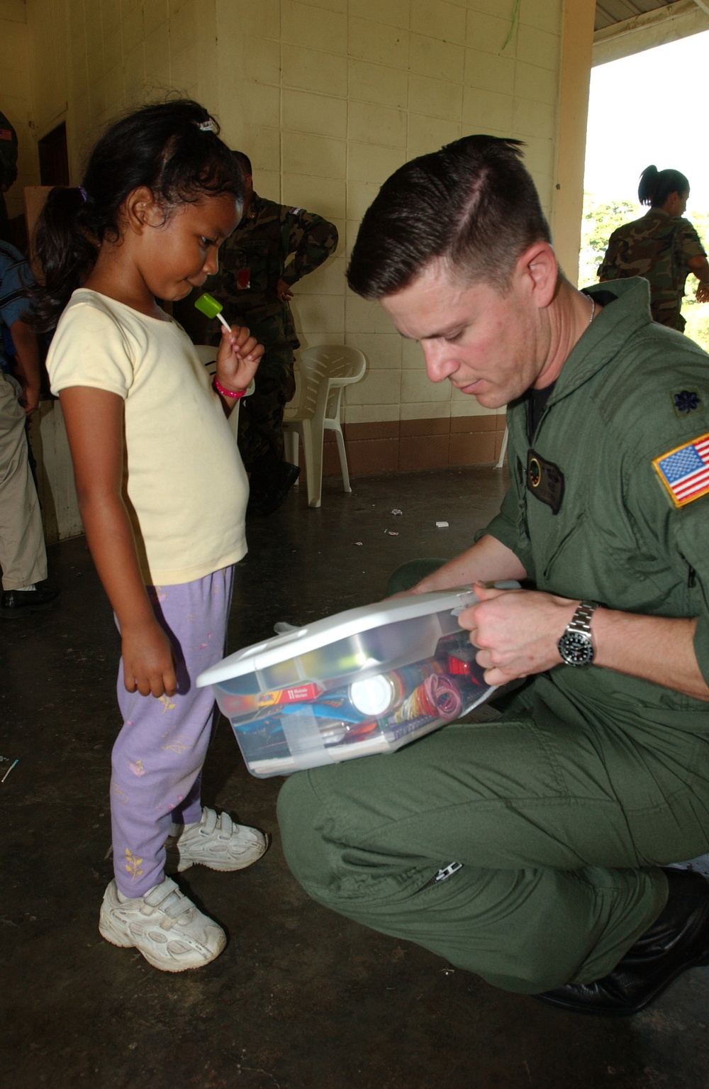 Air Force Lt. Col. Theodore Corallo helps a Honduran girl open her gift.