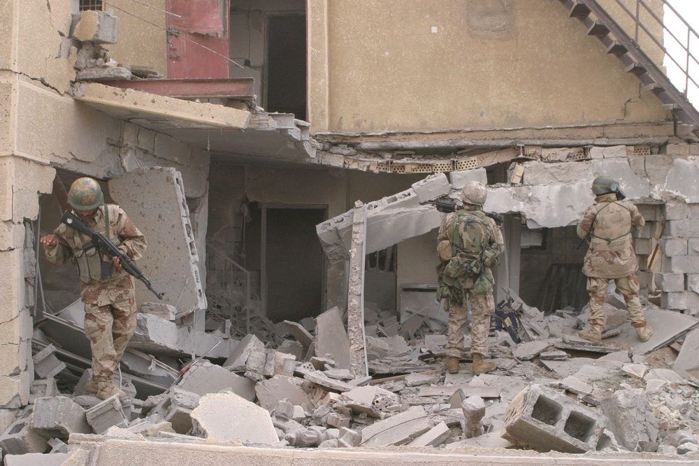 U.S. Marines and Iraqi Armed Forces soldiers clear buildings.