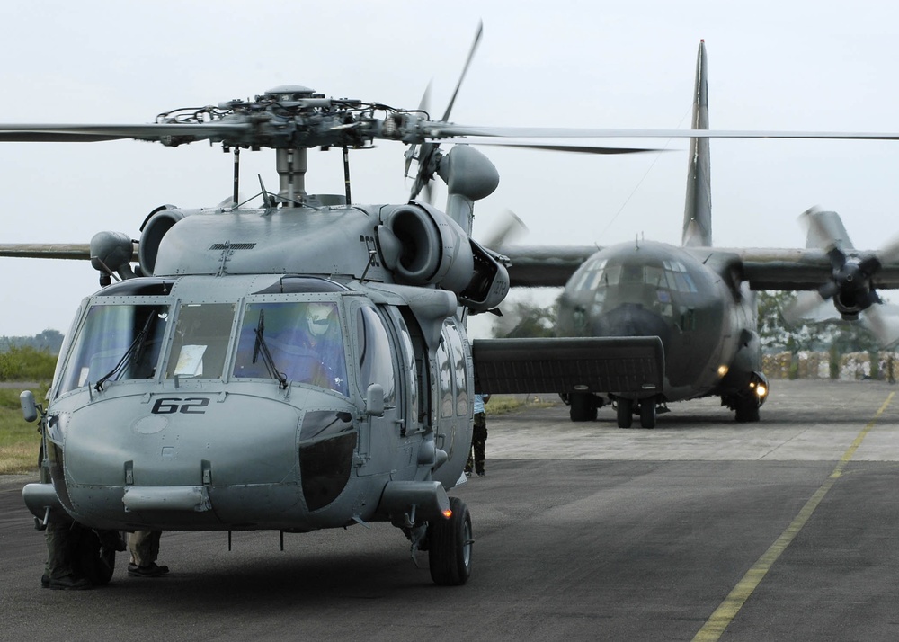 A U.S. Navy SH-60B Seahawk helicopter and an Australian C-130 Hercules prepare for takeoff.