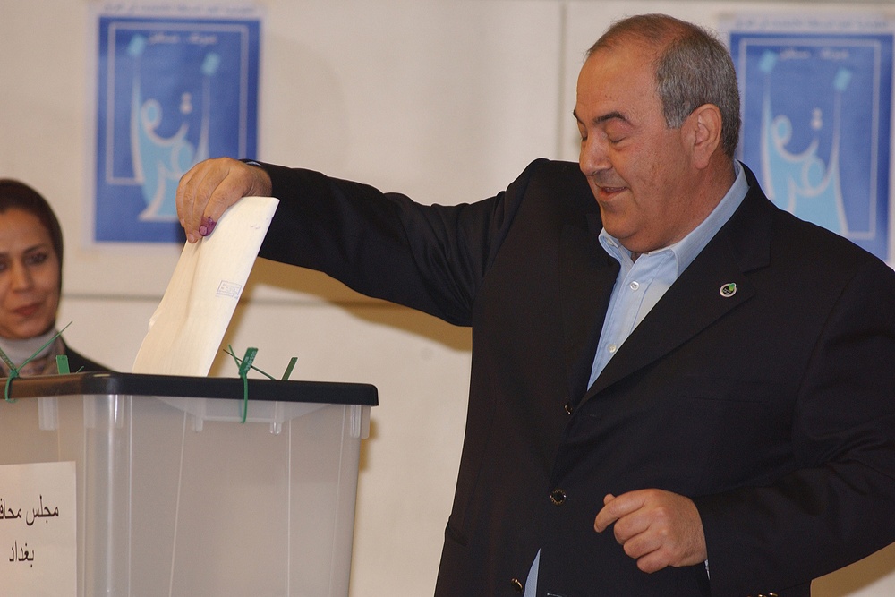 Iraqi Prime Minister Ayad Allawi places his ballot into a ballot box.