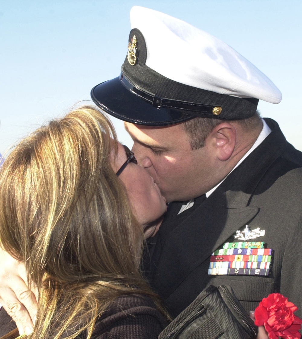 Chief Petty Officer Dominic Brunozzi kisses his wife Diane upon his return.