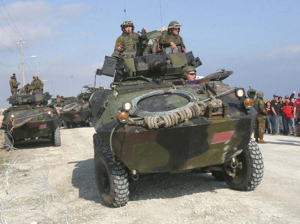 Marines maneuver Light Armored Vehicles into a security perimeter.