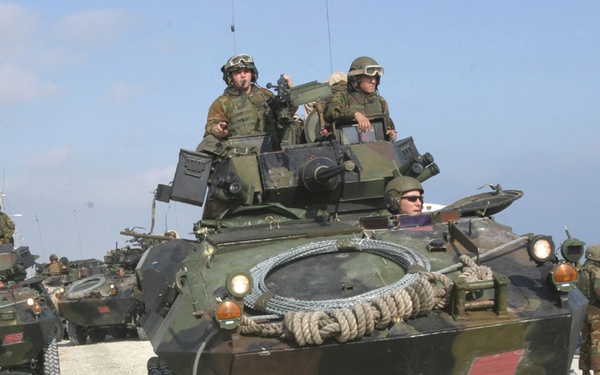 Marines maneuver Light Armored Vehicles into a security perimeter.