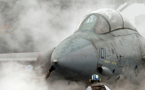 Steam from the catapult envelopes a Navy F-14 Tomcat.