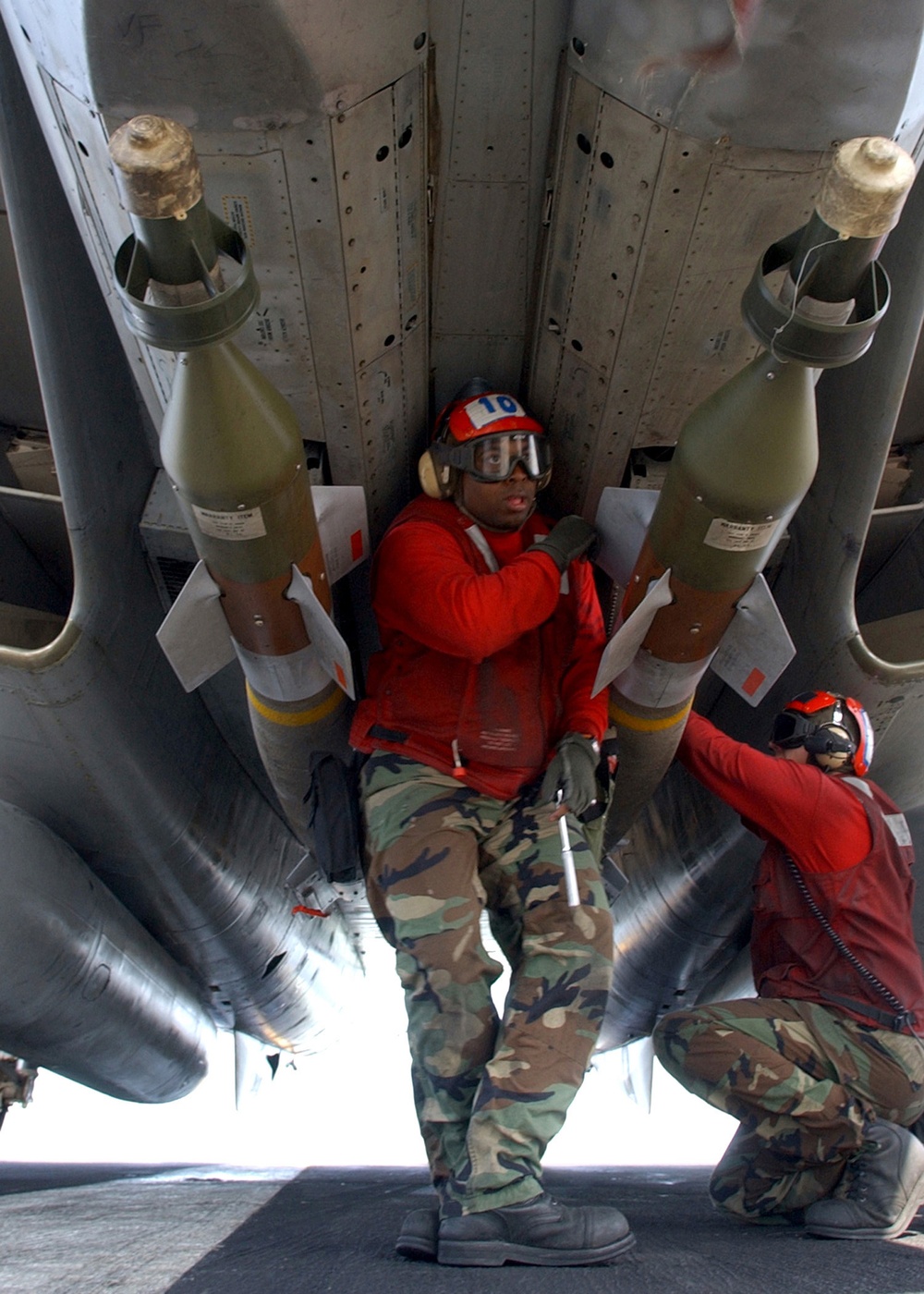 Navy Petty Officer 2nd Class Jamin Garnerhazelwood inspects two laser guided bomb units.