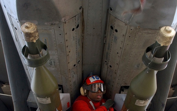 Navy Petty Officer 2nd Class Jamin Garnerhazelwood inspects two laser guided bomb units.