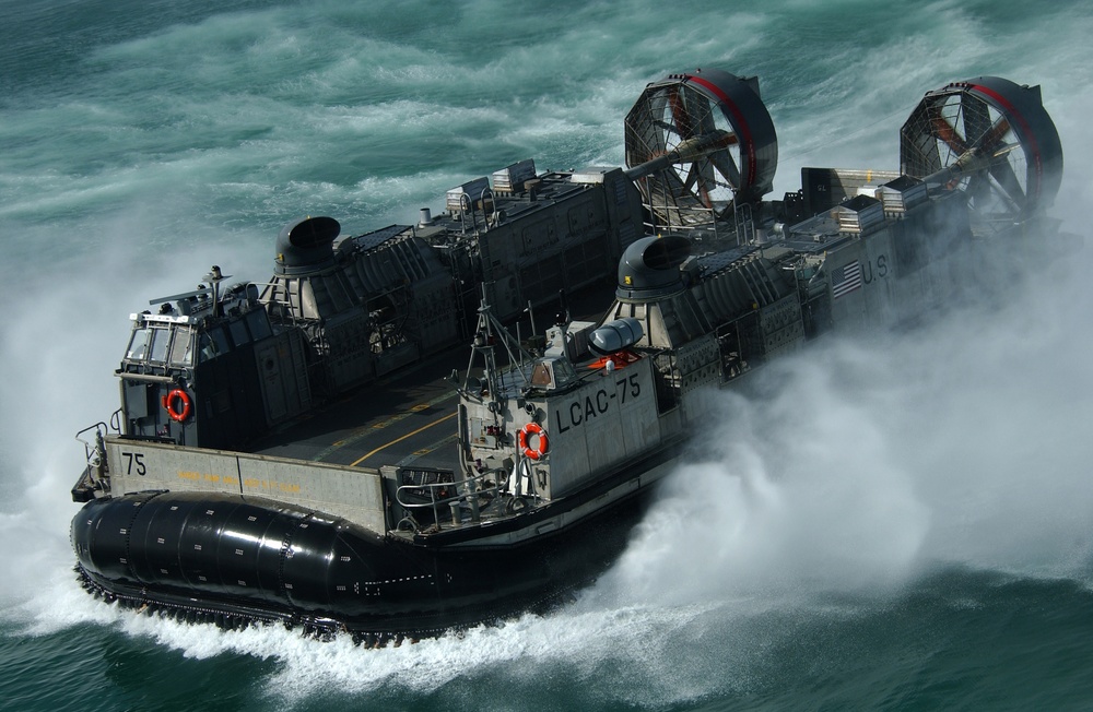 A U.S. Navy Landing Craft Air Cushion kicks up spray as it heads to the Kuwait Naval Base.