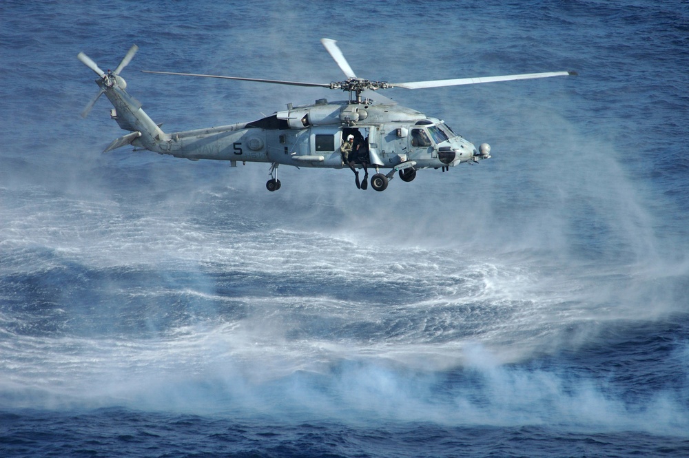 A Navy HH-60H Seahawk hovers over the Pacific Ocean.