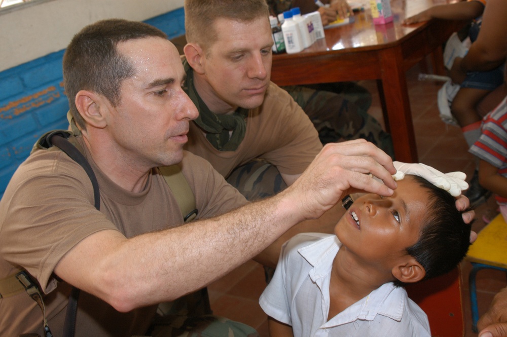 Navy Nurse Lt. William Jansak applies eye drops to a young Nicaraguan boy.