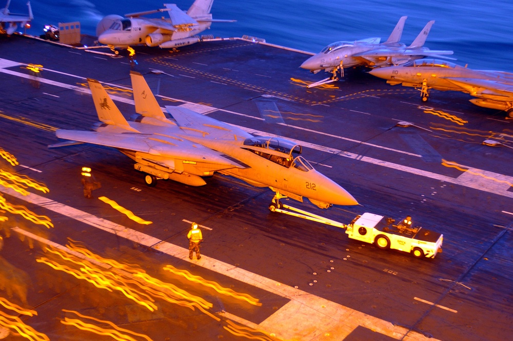 A Navy F-14D Tomcat is towed across the flight deck of the USS Theodore Roosevelt (CVN 71).