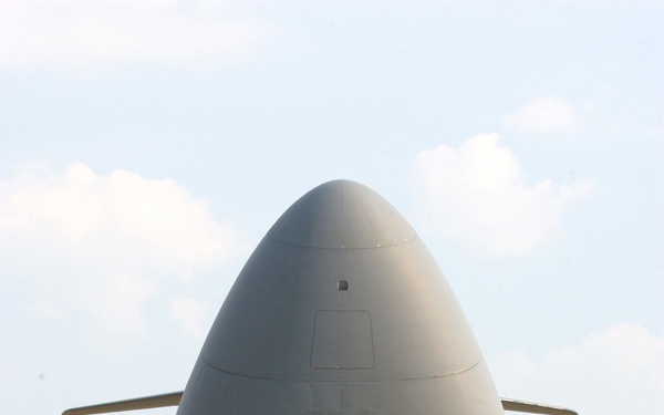 Airmen and crewmembers of a C-5 Galaxy prepare to load mission support cargo.