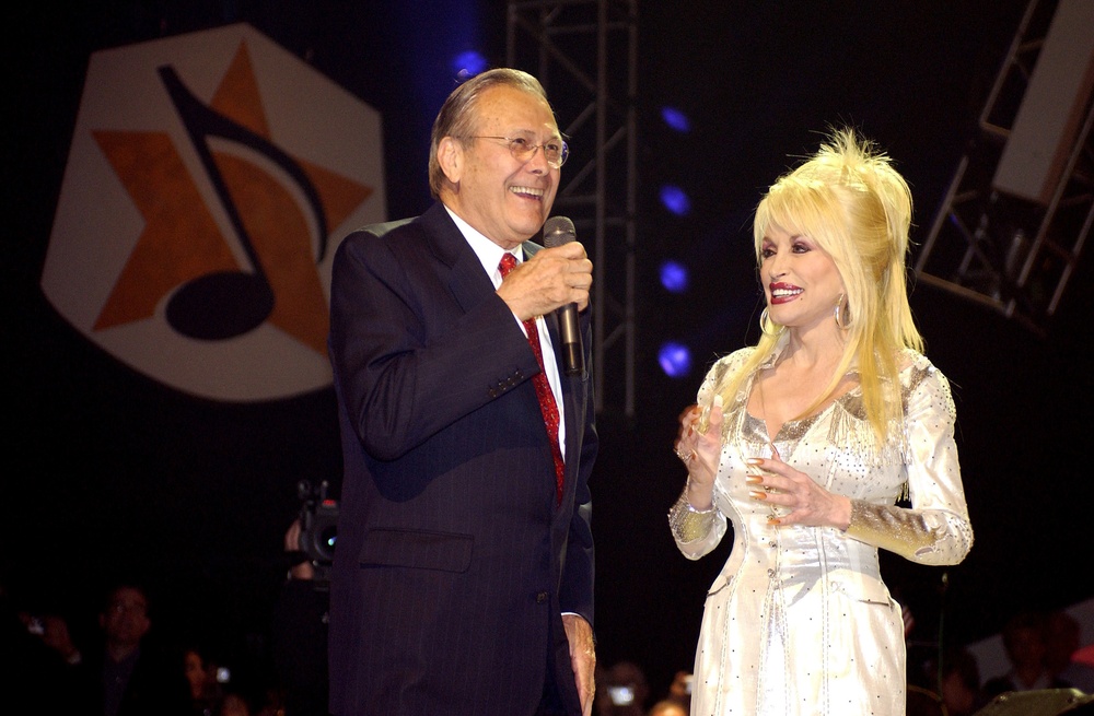 Secretary Rumsfeld joins country music legend Dolly Parton on stage.