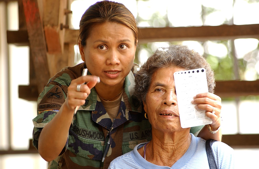 U.S. Army Staff Sgt. Siriporn Brushwood conducts an eye exam on a Thai woman.