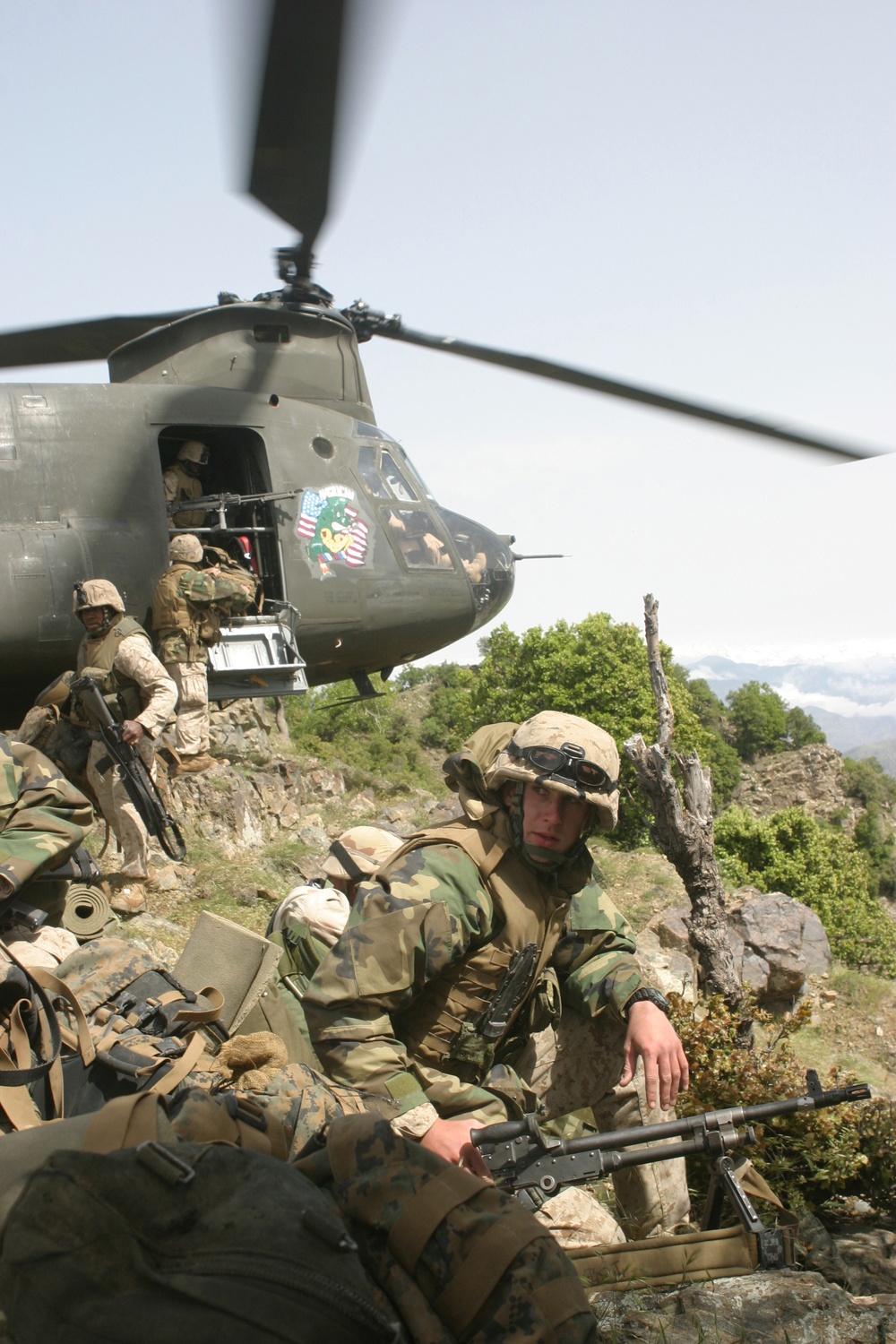 U.S. Marines provide security as fellow Marines exit a CH-46 Chinook helicopter.