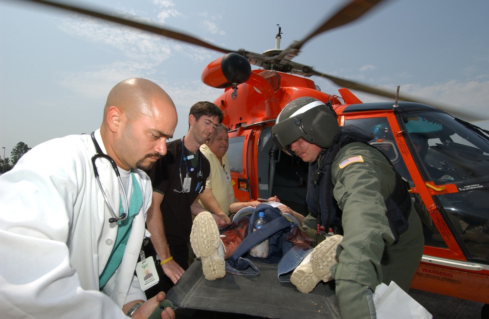Hospital personnel offload an simulated patient on a stretcher.