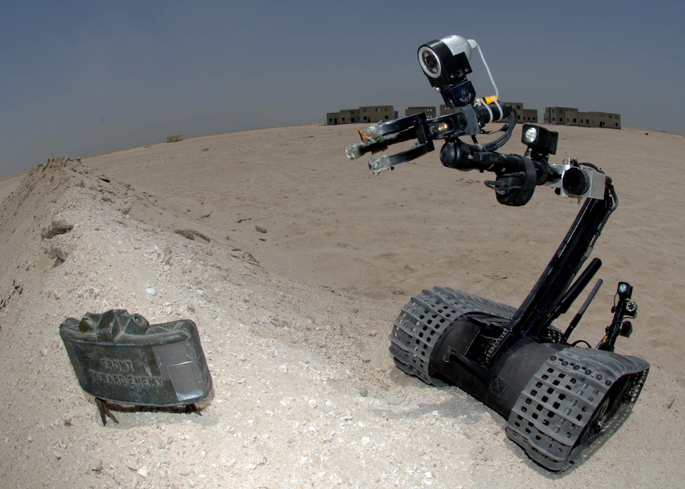 A Navy Talon 3B robot approaches a claymore land mine.