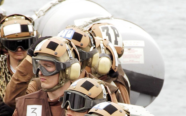 Plane captains watch flight operations from the catwalk.