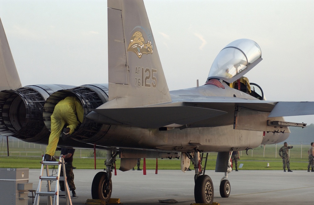 Air National Guard Tech. Sgt. Jose Lopez crawls into the exhaust of an F-15 Eagle fighter.