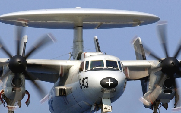 A Navy E-2C Hawkeye approaches for an arrested landing on the flight deck.